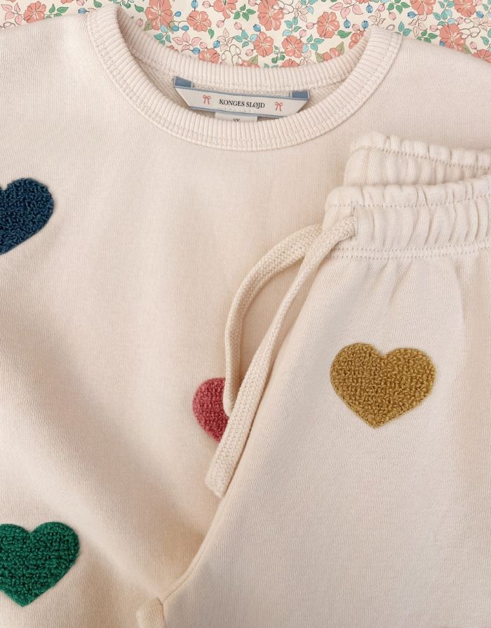 Beige-rosefarbene Lou Sweatpants von Konges Sløjd mit bunten Herzen und elastischem Bund.