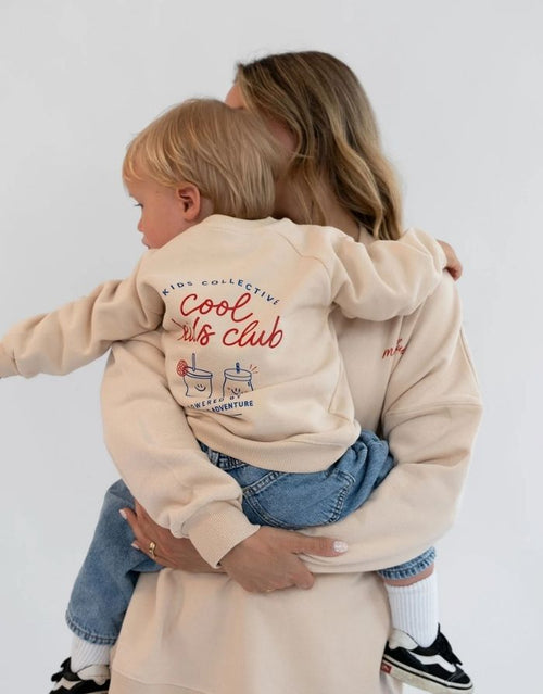 Liliput Oversize Sweatshirt Cool Kids Club für Kinder mit Frontprint und großem „Powered by Vitamins &Adventure“-Rückenprint, am Model.