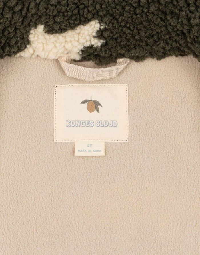 Teddyjacke Jody Dino Silhouette mit weißen Dinosauriern von Konges Sløjd Logo innen im Detail