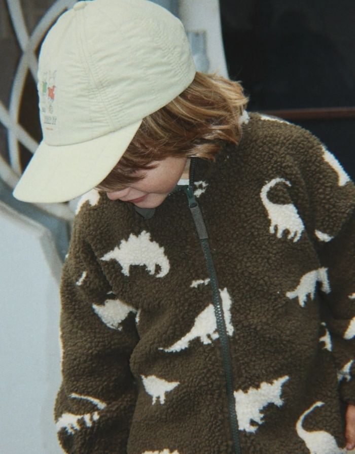 Teddyjacke Jody Dino Silhouette mit weißen Dinosauriern von Konges Sløjd an einem Kind von vorne