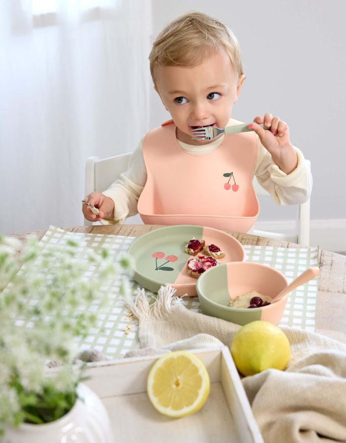 LÄSSIG Runder Kinderteller aus rosa Silikon im Kirsch-Design, BPA-frei, mikrowellen- und spülmaschinengeeignet, für Babys ab 6 Monaten.