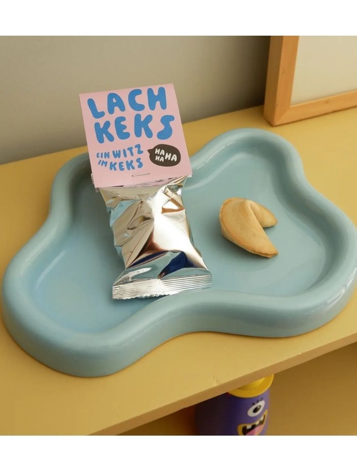 Veganer Lachkeks von Tinyday mit lustigem Witz  im Inneren als kleine Geschenkidee für Kinder und Erwachsene auf einem Tablett
