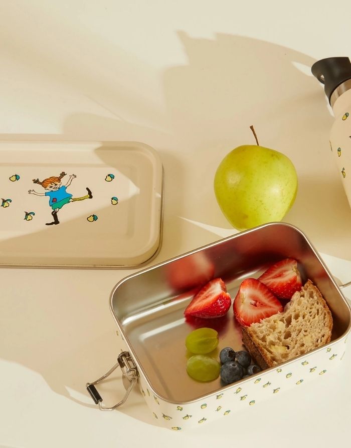 Cremefarbene Pippi Lunchbox von Barbo Toys aus Edelstahl mit klassischer Pippi-Langstrumpf-Illustration und 850 ml Fassungsvermögen mit Brot und Erdbeeren darin