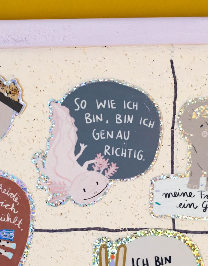 Glitzersticker von Liesels Wicht mit liebevollem Motiv und motivierender Botschaft für Kinder auf glänzendem Glitzervinyl vor einer Wand.