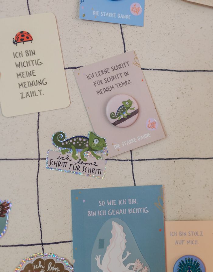 Glitzersticker von Liesels Wicht mit liebevollem Motiv und motivierender Botschaft für Kinder auf glänzendem Glitzervinyl vor einer Wand.