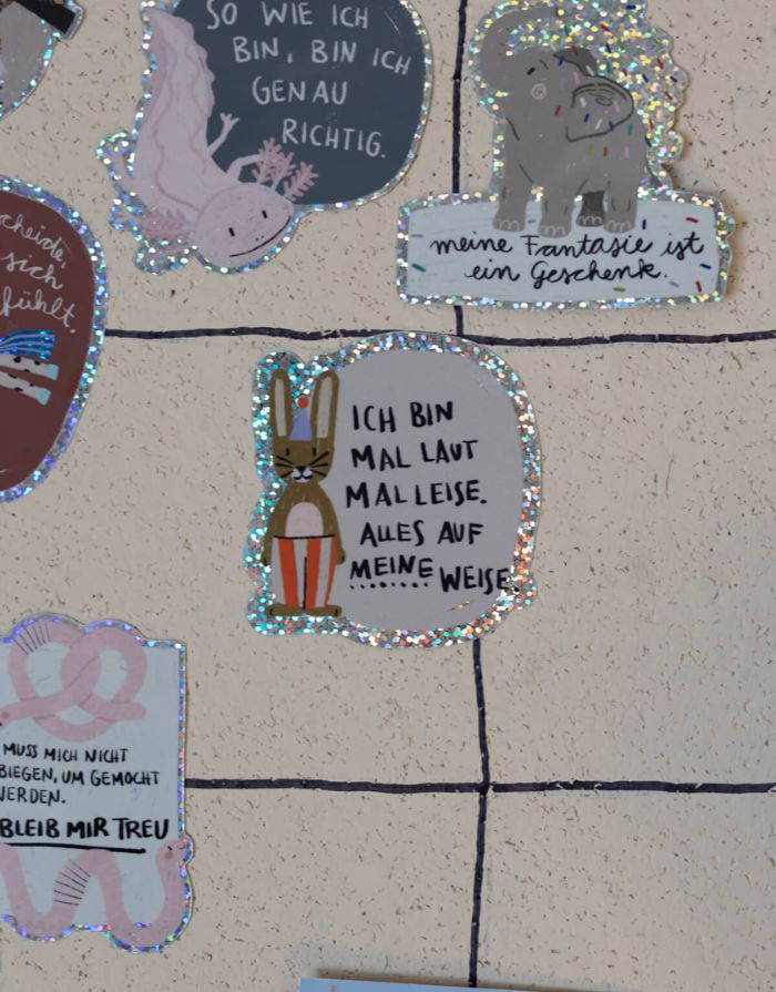Glitzersticker von Liesels Wicht mit liebevollem Motiv und motivierender Botschaft für Kinder auf glänzendem Glitzervinyl auf einer Wand.