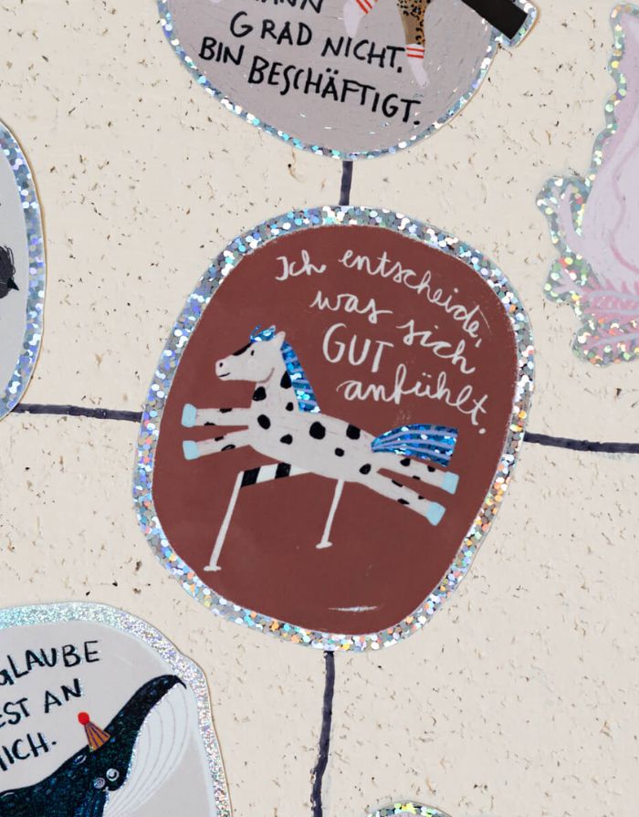 Glitzersticker von Liesels Wicht mit liebevollem Motiv und motivierender Botschaft für Kinder auf glänzendem Glitzervinyl auf einer Wand.