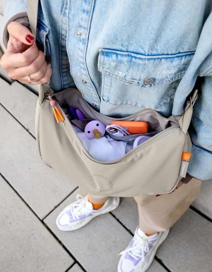 Beige Umhängetasche für Eltern, Stretch Up Bum Bag von LÄSSIG, wasserabweisend, recyceltes Innenmaterial, PFC-frei, mit Kinderwagenhaken.