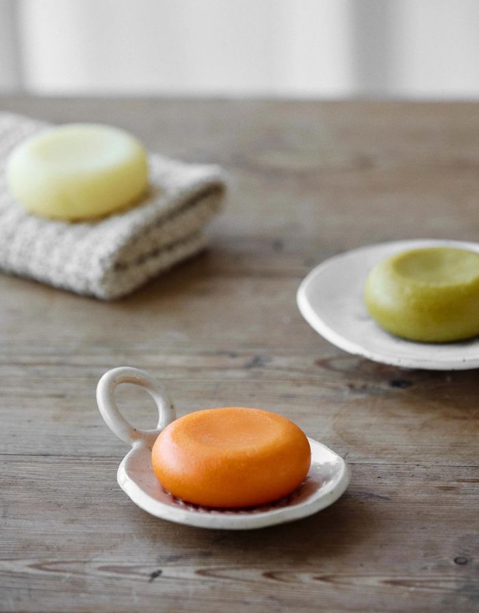 Amalie Rosalie veganer Conditioner-Riegel mit Mangobutter, Jasmin und Rose für trockene Haare in der Farbe orange auf einer Seifenschale