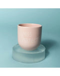 Becher Miss Perfect von SISI House of Style – zartrosa Keramik mit weißem Schriftzug, auf Glassockel vor hellblauem Hintergrund
