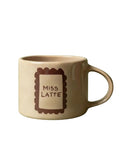 Henkelbecher Beige mit Brauner Schrift