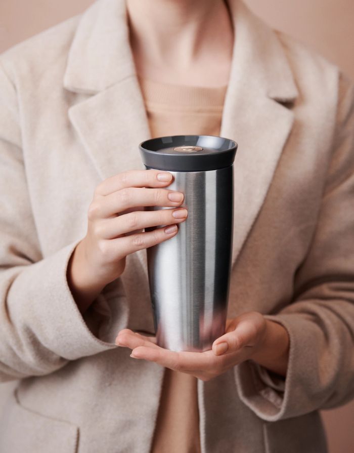 Rosendahl Grand Cru Outdoor Thermobecher in Dunkelgrau aus Edelstahl mit 360-Grad-Trinkdeckel und 400 ml Fassungsvermögen in der Hand einer Frau