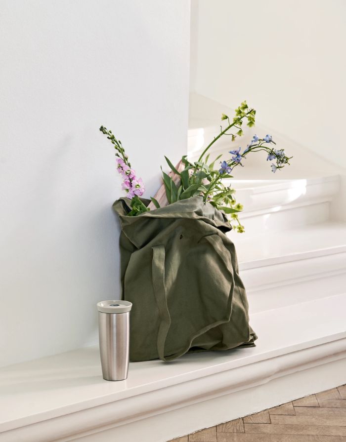 Rosendahl Grand Cru Outdoor Thermobecher in Sand aus Edelstahl mit 360-Grad-Trinkdeckel und 400 ml Fassungsvermögen auf einer Treppenstufe.