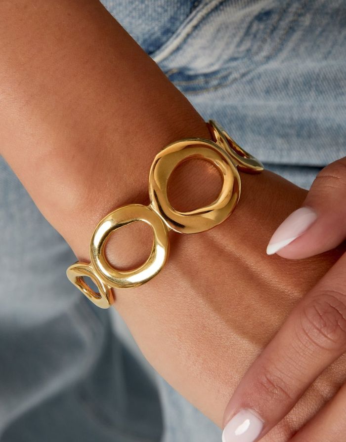 Goldfarbener Armreif im Retro-Stil mit offenen, kreisförmigen Elementen.
Aus 14K-vergoldetem, wasserfestem Edelstahl.