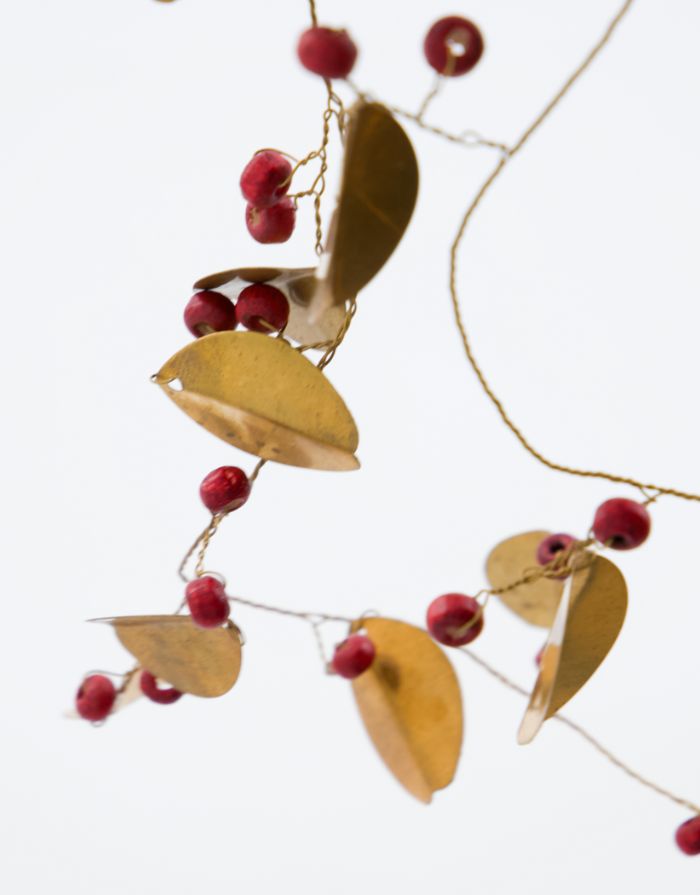 House Doctor Girlande Leafi Messing – handgefertigte Messinggirlande mit goldenen Blättern und roten Mangoholzperlen.