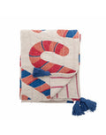 Bunte Candice Decke von Bloomingville in Beige mit geschwungenem Muster in Rot, Blau und Orange sowie blauen Quasten.
