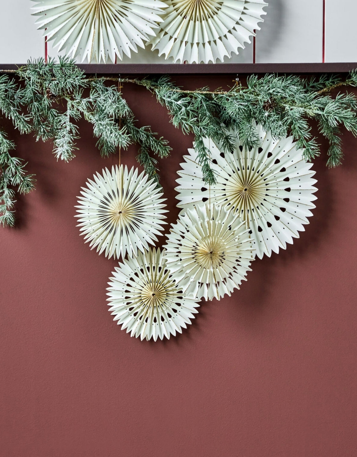 Drei cremefarbene Papersterne von House Doctor aus gefaltetem Papier mit Aufhängeschnur und einem Durchmesser von 20 cm an Tannenzweig