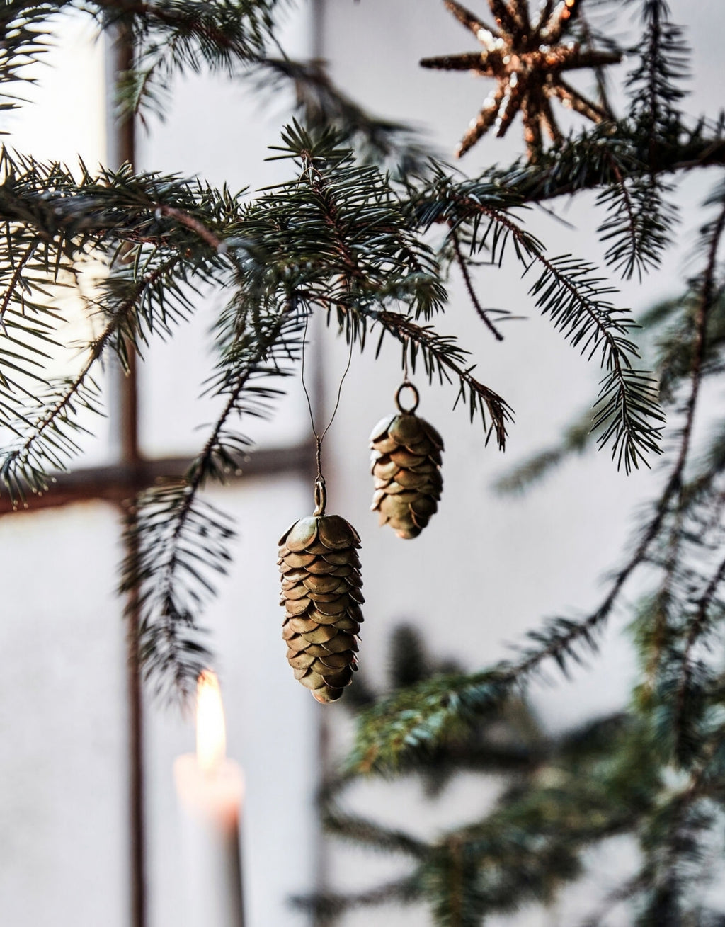 Zwei goldene Cone Tannenzapfen Anhänger von House Doctor aus Eisen in unterschiedlichen Größen am Weihnachtsbaum