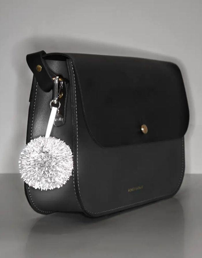 Reflektierender Pom Pom Anhänger in Olivgrün von Firefly Reflectors aus flauschigem Garn mit reflektierendem Faden – dekoratives und sicheres Accessoire für Taschen und Rucksäcke.