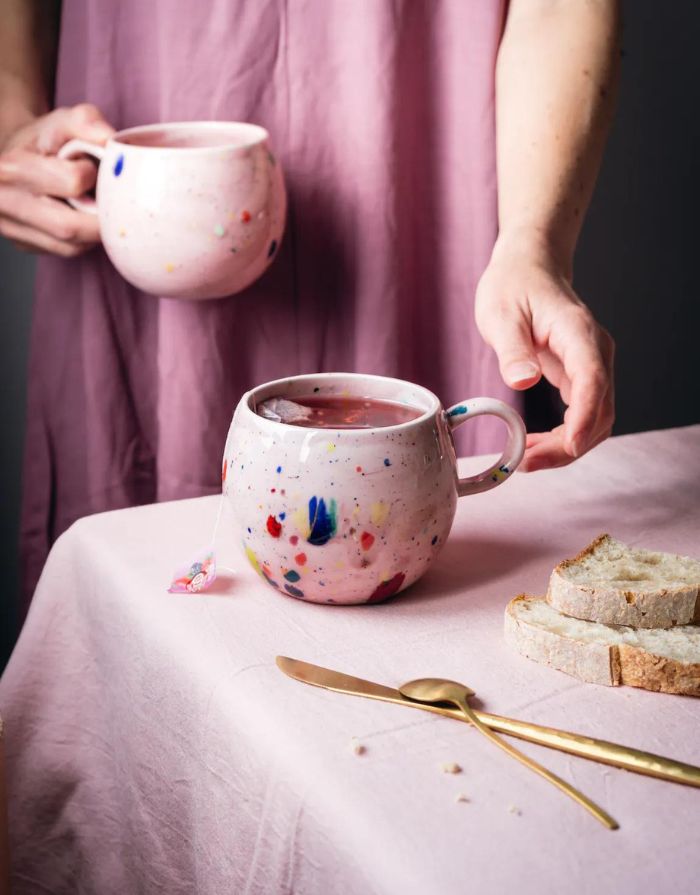 Gesprenkelter Becher in Pink mit 500ml Fassungsvermögen von Egg Back Home auf einem Tisch mit Tee darin